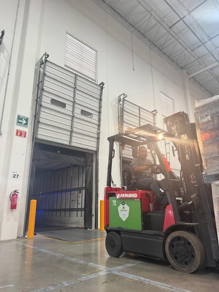 Operador con montacargas Raymond en muelle de carga abierto hacia caja seca en CEDIS Silodisa